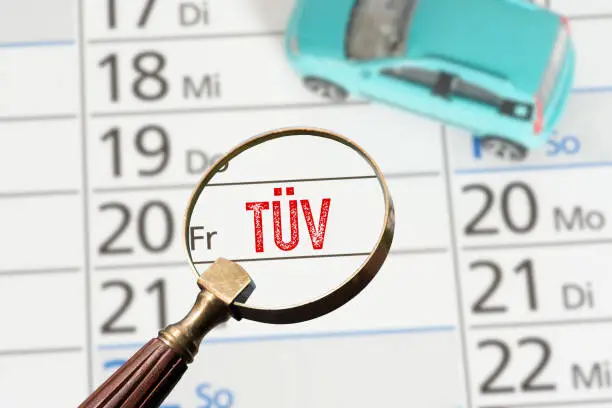 A car and a calendar with the date for a technical inspection Tüv