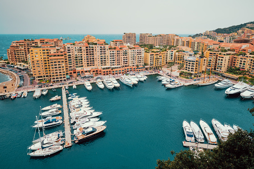 Harbor with moored yachts and boats and residential houses in Moncte Carlo, Monaco