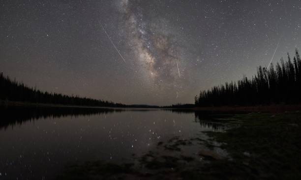 vía láctea y reflexión sobre un lago alpino con 3 meteoros en el cielo - lluvia de meteoritos fotografías e imágenes de stock