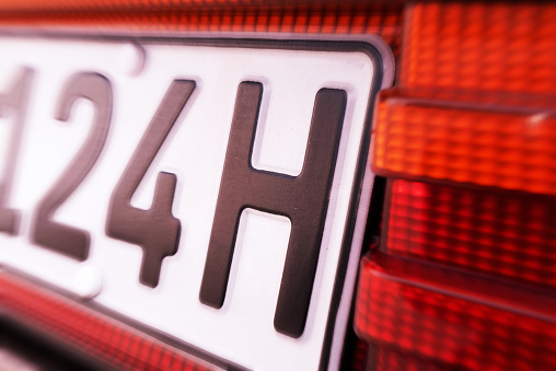 Close-up of an H license plate on a classic car