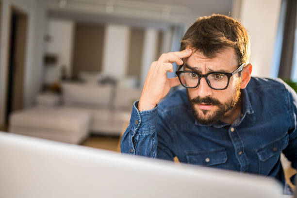 istock Worried man working on computer at home office. 1334461333