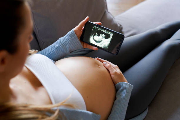 schwangere frau, die medizinische online-scans abschließt - human pregnancy telephone ultrasound family stock-fotos und bilder