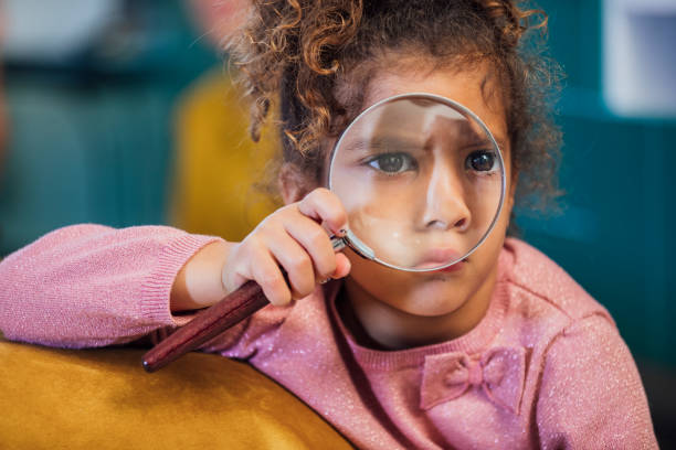 istock Young Girl Using Magnifying Glass 1334461640