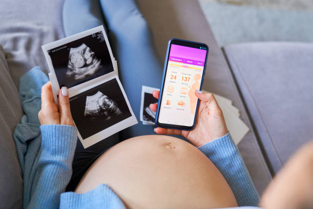 kobieta pregnat korzystająca z aplikacji mobilnej - human pregnancy telephone ultrasound family zdjęcia i obrazy z banku zdjęć