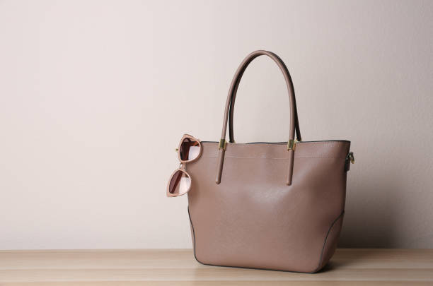 istock Stylish leather woman's bag on wooden table. Space for text 1334464756