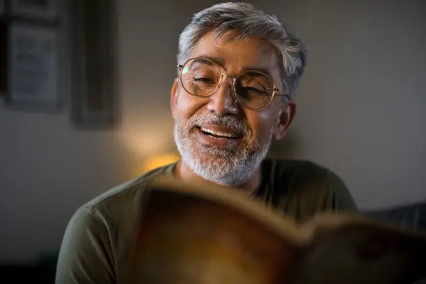 Photo of Man reading book at home