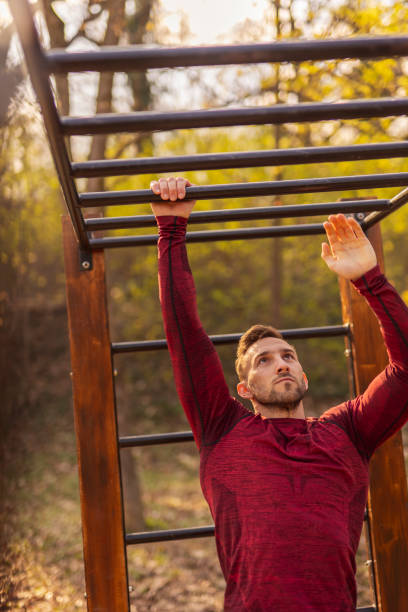 istock Man working out on monkey bars in a street workout park 1334467749