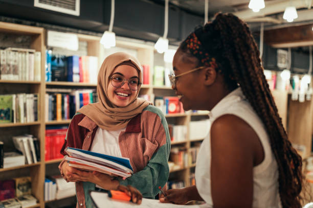 istock Two diverse women studying together at library 1334469577