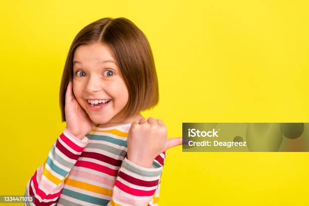 Photo Portrait Little Girl Touching Cheek Pointing Copyspace Thumb Smiling Happy Isolated Bright Yellow Color Background Stock Photo - Download Image Now