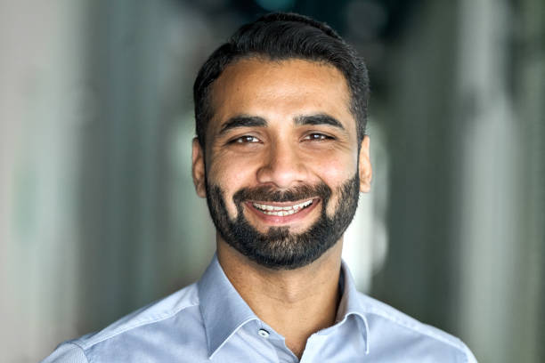 istock Smiling confident indian businessman looking at camera standing in office. 1334472742