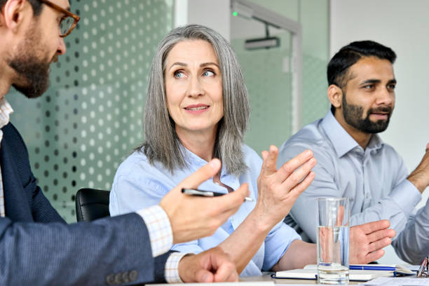 istock Smiling female ceo discussing project with managers colleague at table meeting. 1334472926
