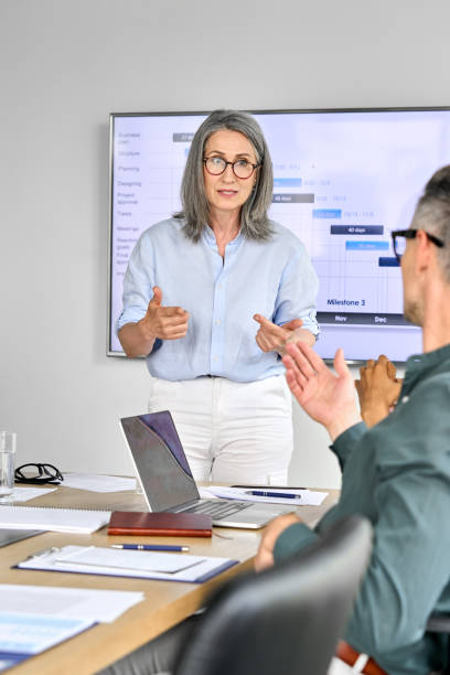 Executive corporate team discussing presentation in boardroom office.