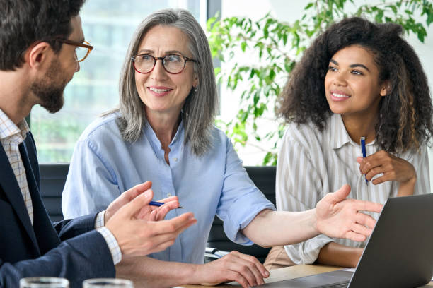 uomini d'affari internazionali che discutono di piano finanziario alla riunione della sala riunioni. - leadership business women senior adult foto e immagini stock