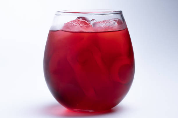 istock Red water with ice in a clear glass on a white background. 1334474486