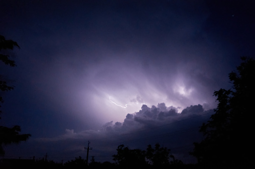 Relámpagos y tormentas eléctricas en el cielo nublado nocturno. Relámpagos brillan a través de las nubes. Tiroteo nocturno photo