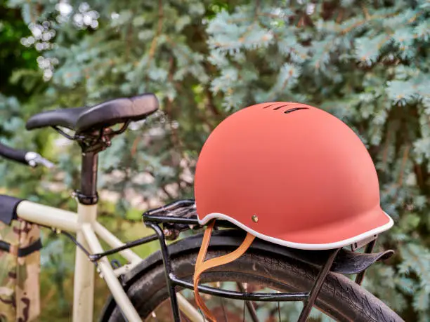biking helmet on racks of a touring or gravel bike against forest background - safe riding, recreation and commuting concept