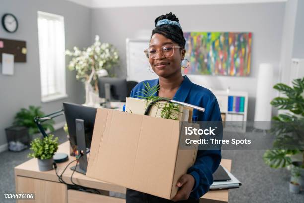 Stylish Businesswoman Wearing Elegant Blue Clothes And Glasses Is Promoted To Managerial Position Changes Office Leaves Company Carries Carton With Packed Accessories Change Of Job Stock Photo - Download Image Now