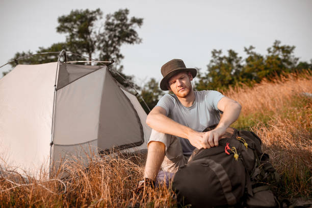 istock A man sitting on the ground and packing his backpack 1334476196