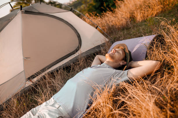 istock A man laying on the grass near his tent and sleeping 1334476197