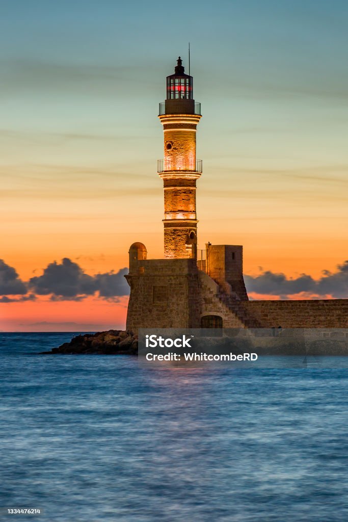 Ancient Venetian lighthouse guarding the old port of Chania, Greece at Sunset Crete Stock Photo