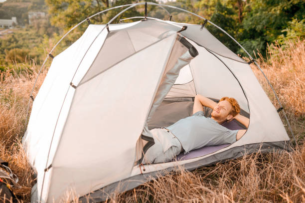 istock A man laying in his tent and feeling sleepy 1334476287