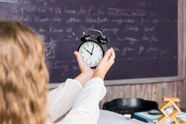 blond girl holding vintage black alarm clock.stressed kid worried about deadline. reminder time to go back to school. meeting or breaking deadline.back to school.time management concept. - clock clock face blank isolated imagens e fotografias de stock