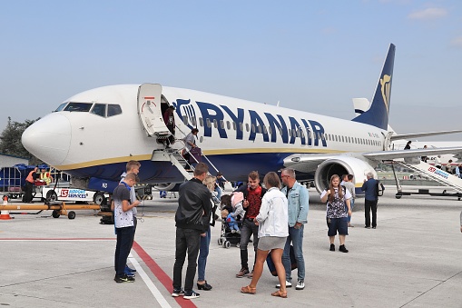 Maun International Airport, Botswana - December 19th 2022:  Passengers boarding a small jet aircraft, a Embraer190 ZS-YAY from FlyAirLink on the open tarmac in Maun Airport