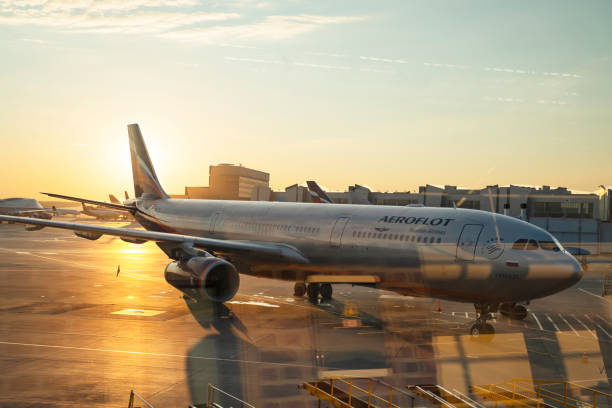 avion de ligne de passagers, avion contre le ciel bleu coucher du soleil. le soleil couchant. coucher de soleil - sheremetyevo photos et images de collection