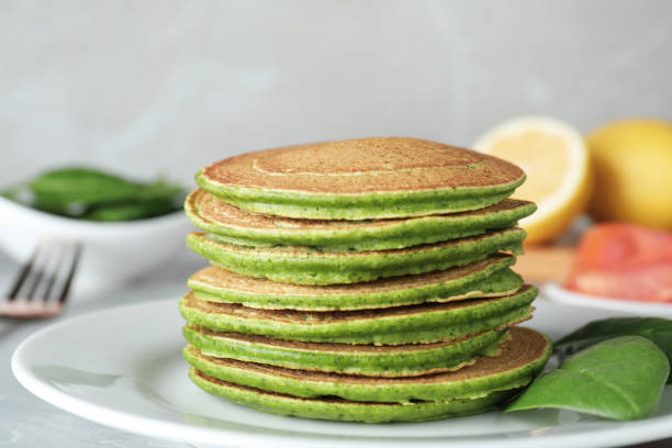 istock Tasty spinach pancakes on light grey table, closeup 1334481851