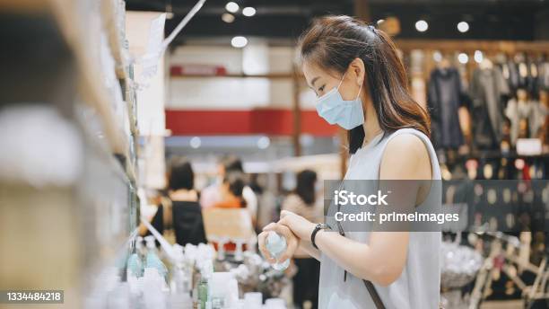 New Norm Asian College Female Chinese Taiwanese Choosing Cosmetic Beauty Product Make Up Testing In Her Hand Stock Photo - Download Image Now