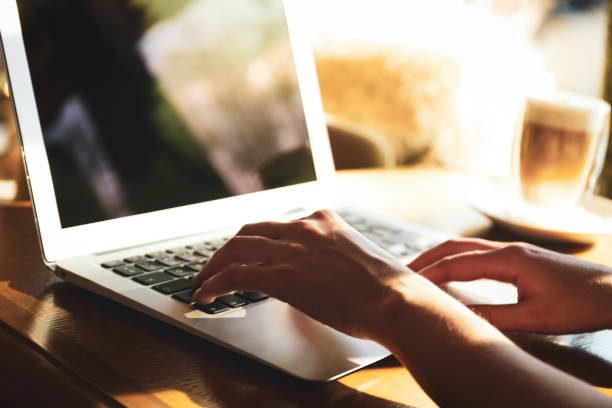 istock Woman using laptop at table, closeup of hands 1334485405