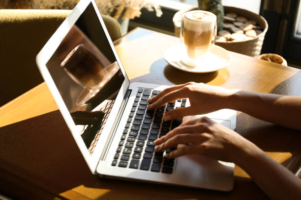 istock Woman using laptop at table, closeup of hands 1334485524
