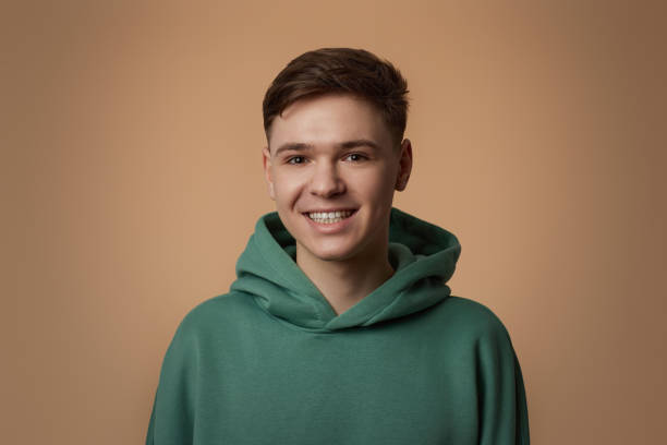 istock young handsome guy in green sweatshirt smiling 1334485580
