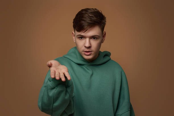 istock young handsome guy in sweatshirt talking to someone 1334486719