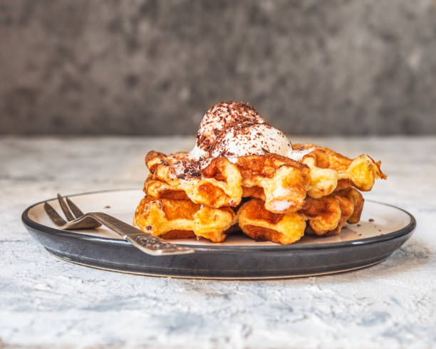 istock Waffles with ice cream and chocolate chips on a light saucer and dessert fork 1334486950