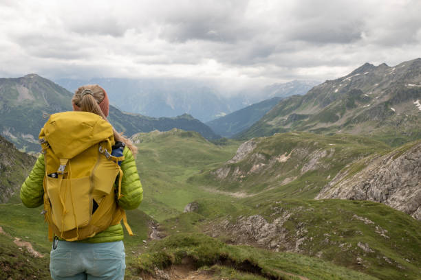 une jeune femme fait de la randonnée dans les alpes suisses et contemple le paysage - success determination idyllic carefree photos et images de collection