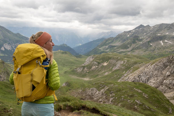 une jeune femme fait de la randonnée dans les alpes suisses et contemple le paysage - success determination idyllic carefree photos et images de collection