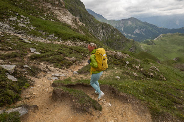 jeune femme randonne dans les alpes suisses, elle descend le sentier - success determination idyllic carefree photos et images de collection