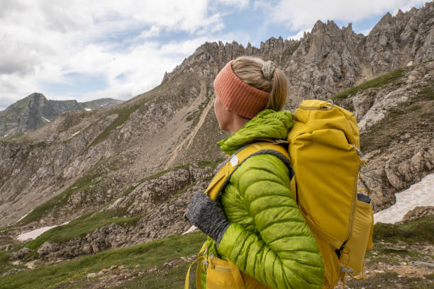 une jeune femme fait de la randonnée dans les alpes suisses et contemple le paysage - success determination idyllic carefree photos et images de collection