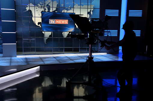 Camera man in the news studio. In silhouette.