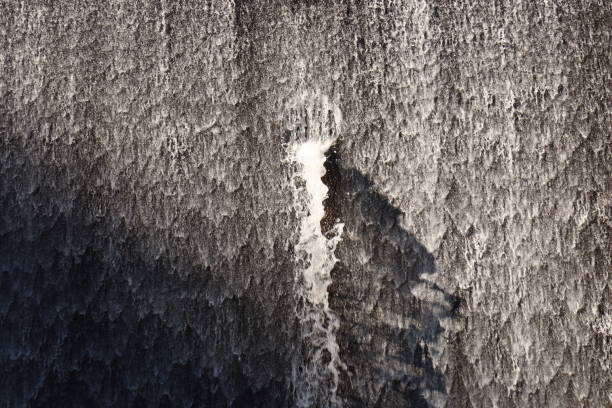 Water flowing quickly over a dam wall. This photo contains motion blur.