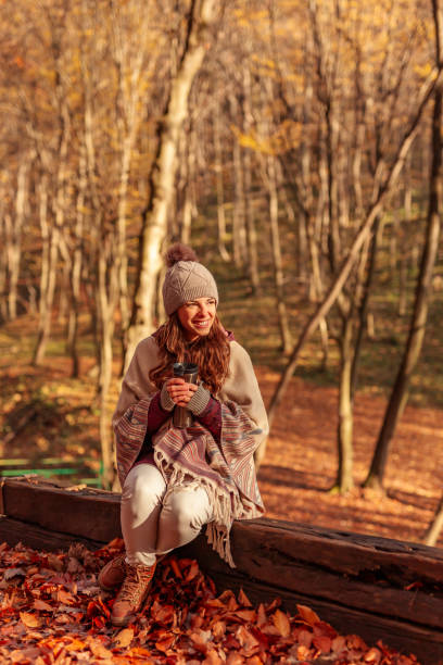istock Woman drinking coffee while spending sunny autumn day outdoors 1334493096
