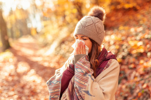 Woman blowing nose on an autumn day stock photo