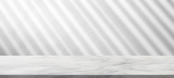 istock Marble table with window shadow drop on white wall background for mockup product display 1334493368