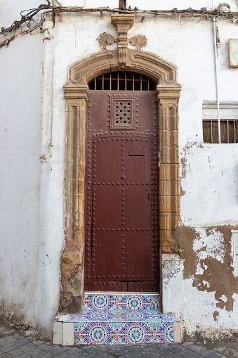Typical arch door with colorful tiled steps in residential house in the medina of Casablanca, Morocco