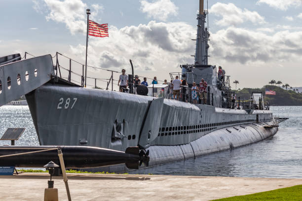sous-marin uss bowfin avec beaucoup de touristes à bord amarré à côté de l’uss arizona memorial visitor center à pearl harbor - submarine navy usa military photos et images de collection