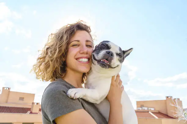 Photo of Happy woman holding bulldog.