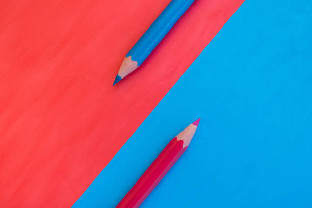 istock Pink and blue background divided diagonally with two matching colored pencils 1334499492