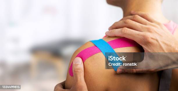 Kinesiology Taping Physical Therapist Applying Kinesiotape On Injured Patient Shoulder Copy Space Stock Photo - Download Image Now