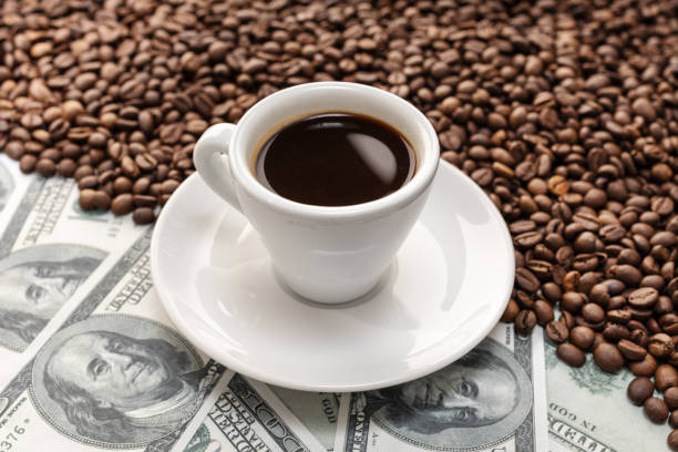 Cup of coffee on Coffee beans and dollar banknotes background stock photo